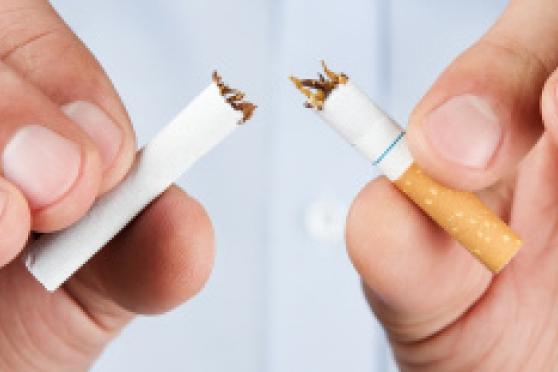 Photo: Man's hands breaking a cigarette in half